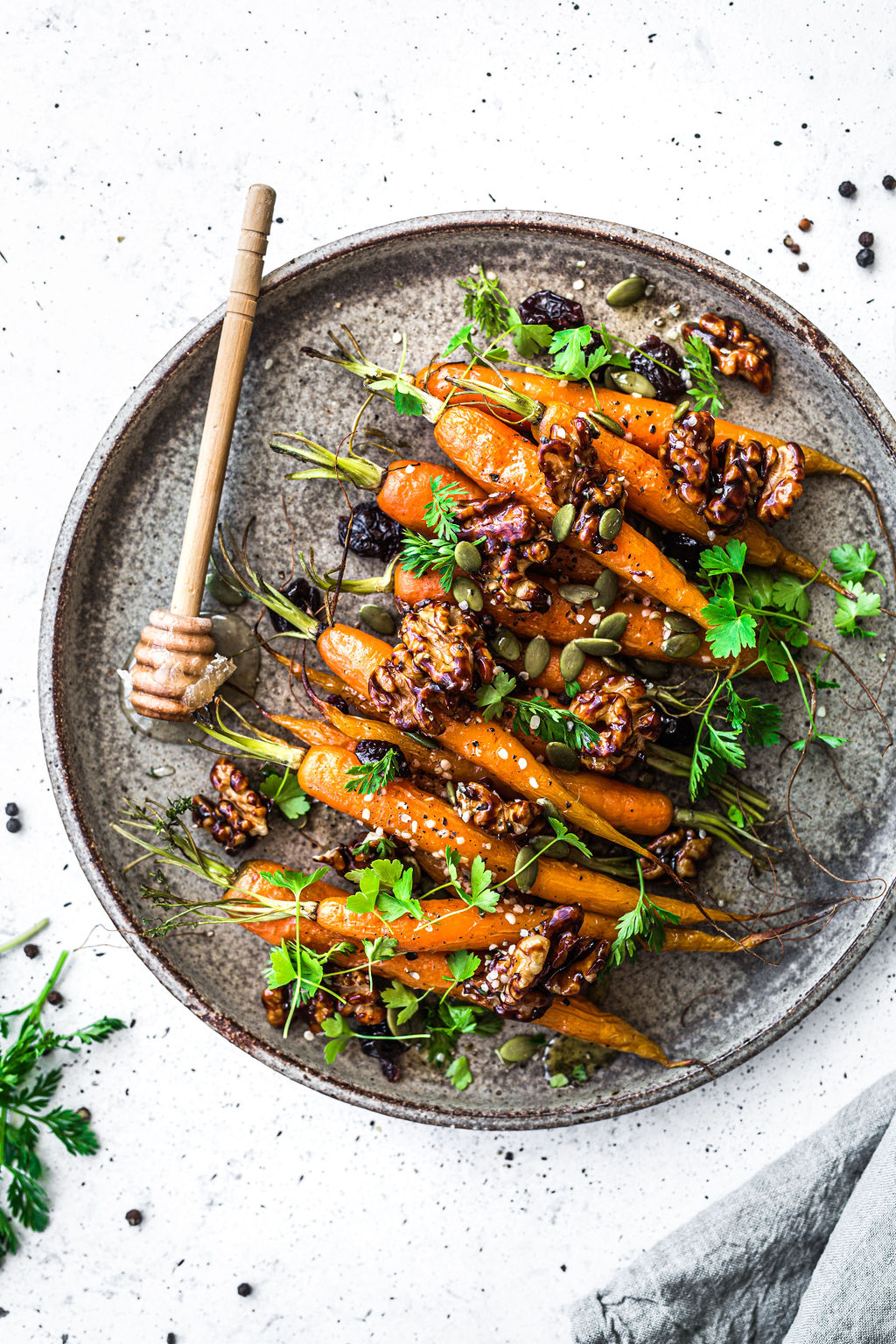 Carrots! This is a gorgeous flatlay image of a bunch of roasted carrots on a plate. They're sprinkled with greens and honey. DELISH.